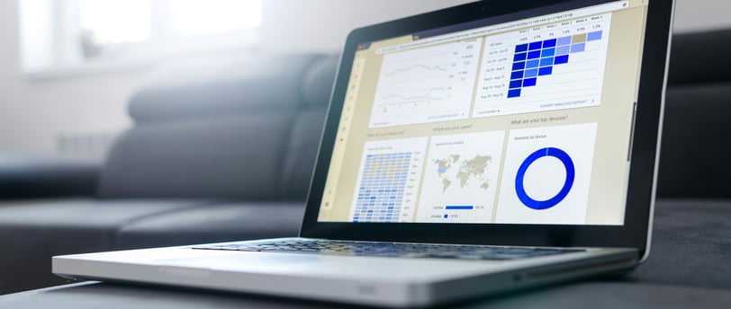 Computador exibindo gráficos financeiros com indicadores de investimentos.