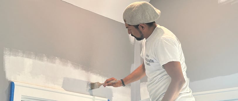 a man is painting a wall with a paint roller
