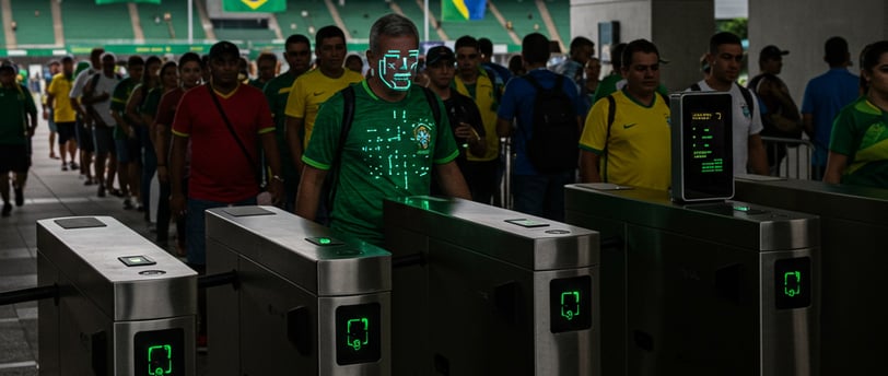 a man in a green shirt is standing in front of a line of turnstile