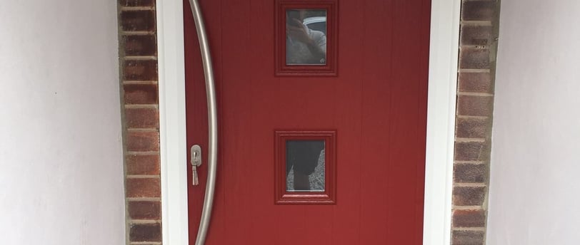 a new red composite front door with 4 squares of glass and curved long handle
