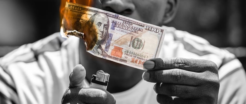 man setting 100 dollars on fire
