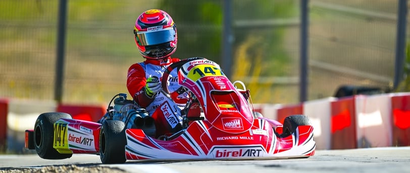 Kart rouge numéro 14 en pleine course sur une piste de karting.