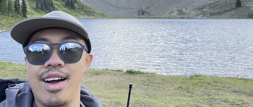 a man with sunglasses and a backpack on a mountain