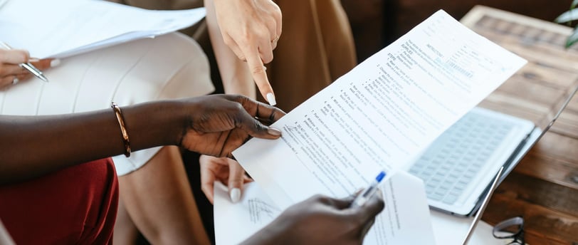 a person holding a piece of paper with a person holding a pen