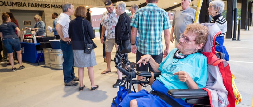 Person in a automatic wheelchair next to a small crowd of people