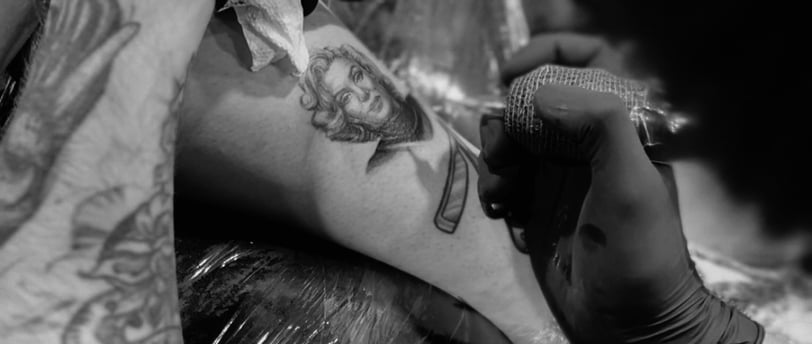 a man is getting a tattoo on his arm of a detailed marilyn monroe