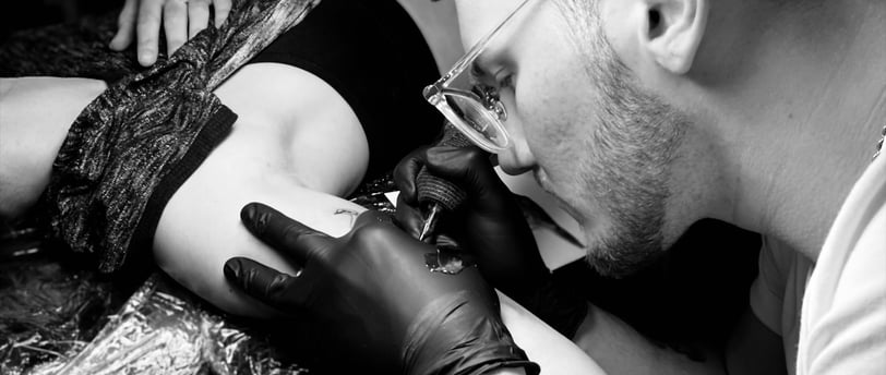 a man is getting a tattoo on his arm in Kaunas