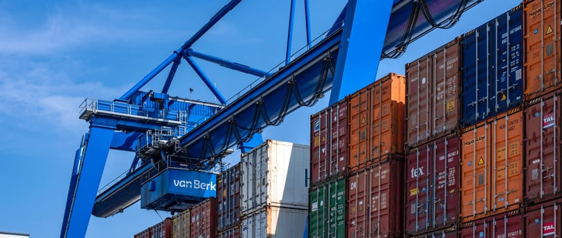 a crane is lifting a container at a container yard