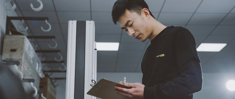 a man in a black shirt is holding a clipboard