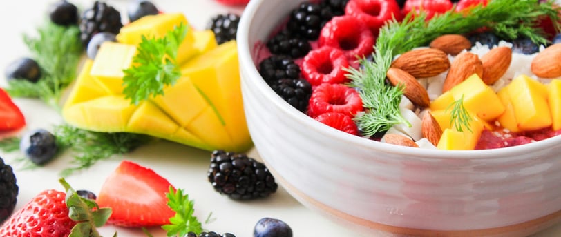 a bowl of fruit and nuts on a table