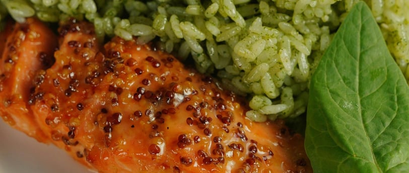 a plate of food with salmon, rice and a lemon wedge