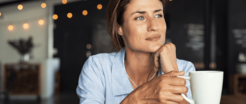 Woman sipping coffee and reflecting on fertility journey