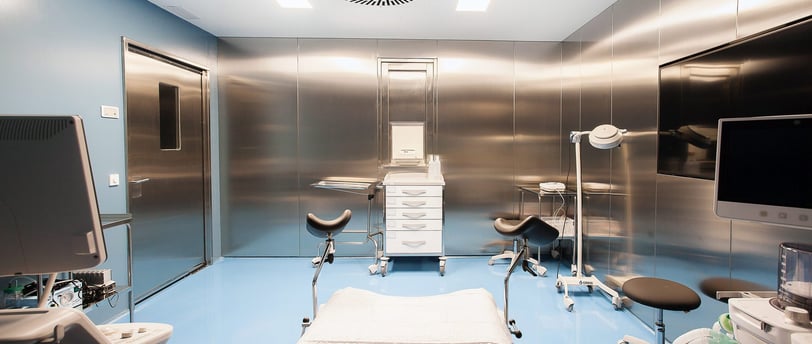 High-tech fertility clinic egg collection room with surgical chair and monitors