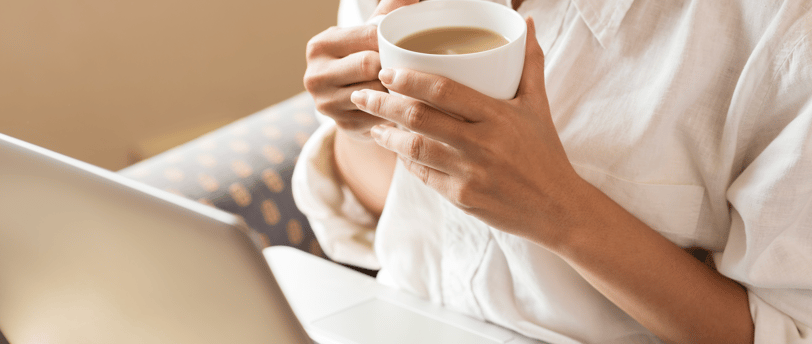 Woman drinking tea while researching fertility online