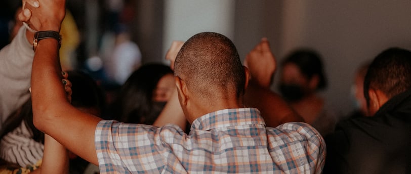 people holding hands up in the air in prayer and praise