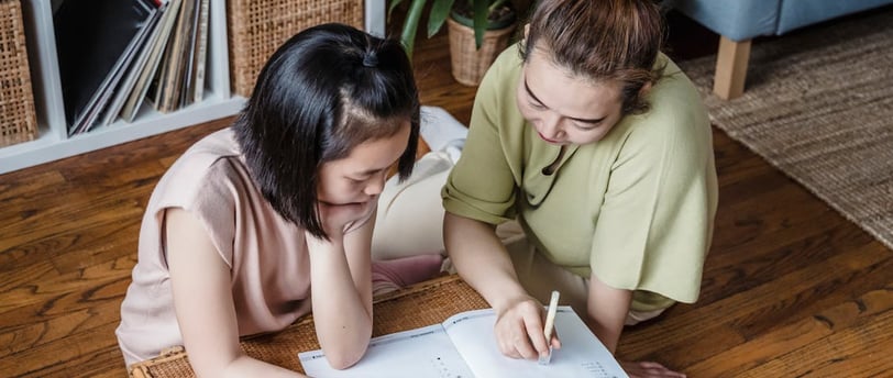 A mother and daughter study together.