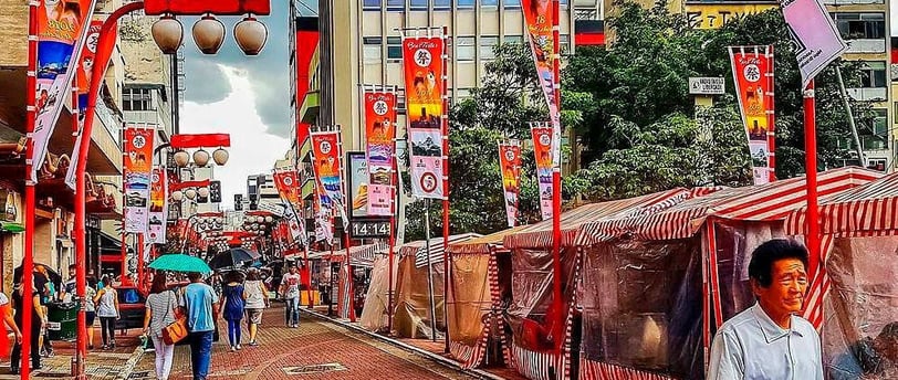 Rua Liberdade em São Paulo, com lanternas japonesas, bandeiras e uma feirinha.