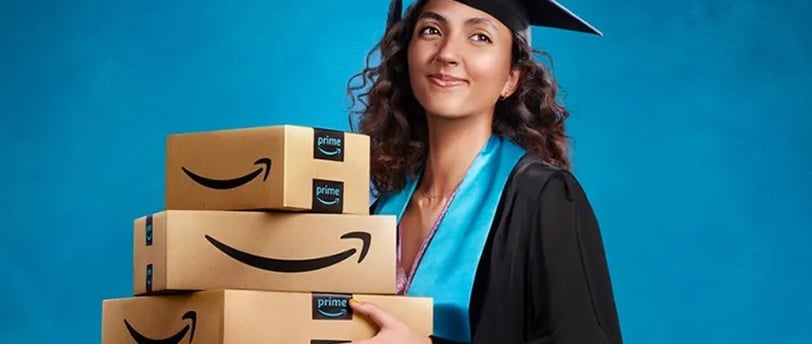 a woman in a graduation gown holding a stack of amazon boxes
