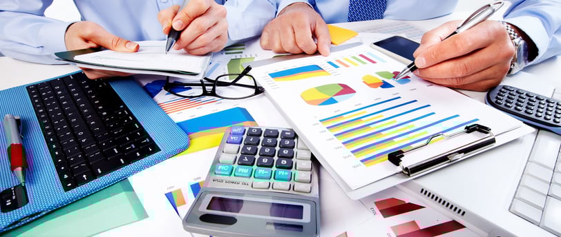 um homem de camisa azul e gravata fazendo cálculos da empresa