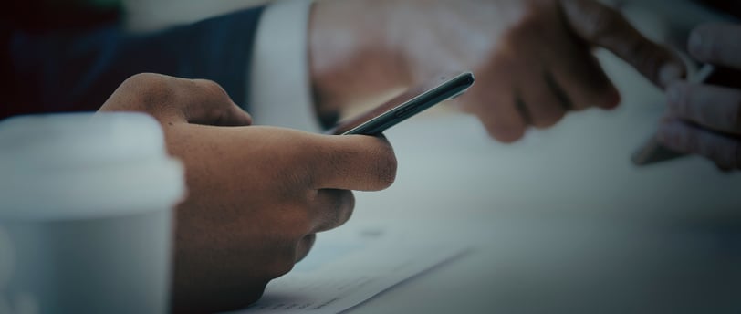 Advogado mexendo no celular em reunião