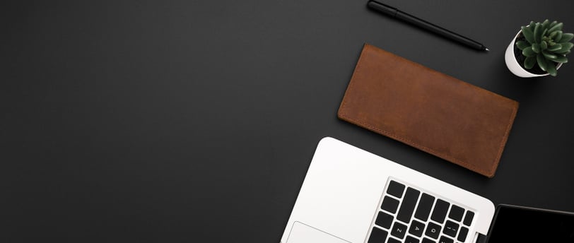 Carteira, caneta e notebook na mesa