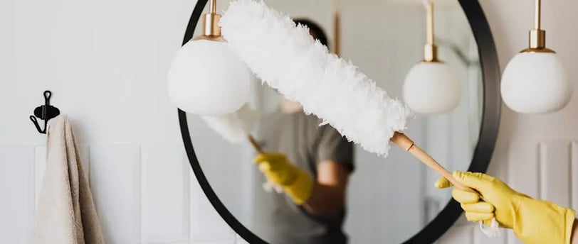 a person cleaning a mirror in a bathroom