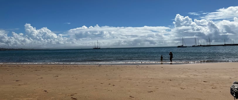 céu com nuvens sob mar com barcos ao fundo