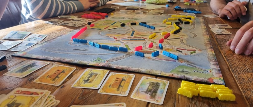 Een tafel met het bordspel Ticket to Ride