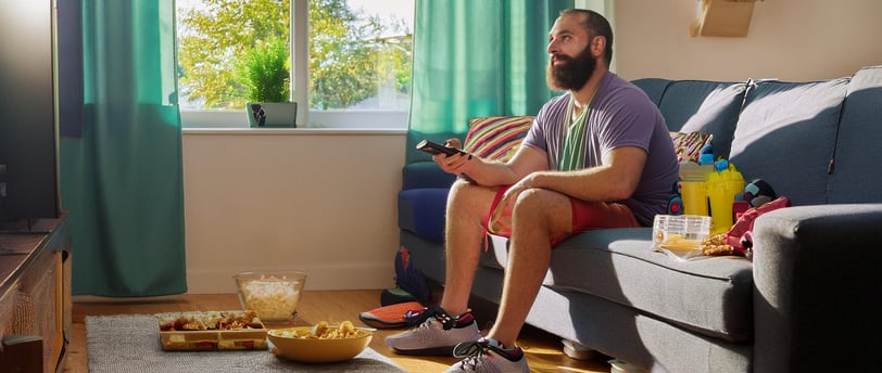 imagem de pessoa sedentária sentada em um sofá