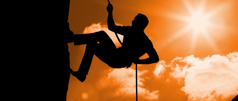 a man climbing a rock face on a rock
