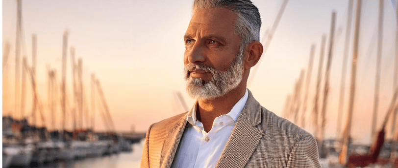 Well dressed man standing port side at golden hour