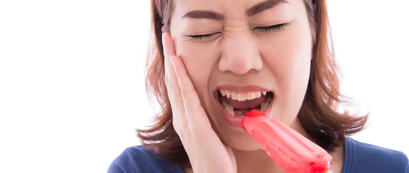 a woman with hands on cheek and mouth open with icecream on one hand