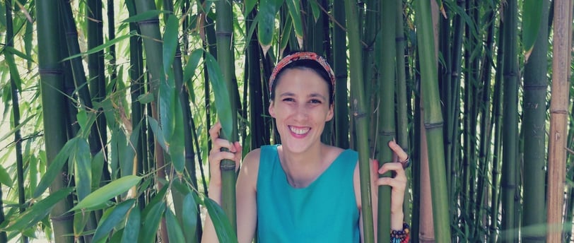 a woman standing in front of a bamboo tree