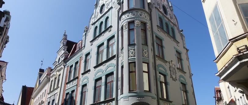 a building with a clock tower in the middle of a city