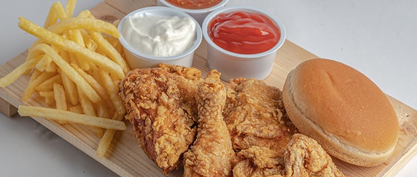 pollo frito crujiente con patatas y salsas mayonesa y ketchup