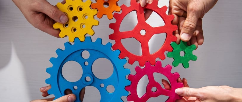 a group of people holding colorful gearswheels