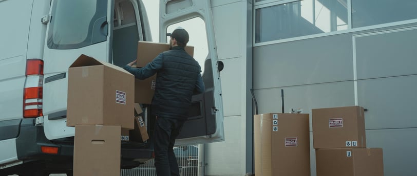 a man is moving boxes into a van