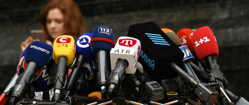 a woman standing at a podium with microphones and microphones