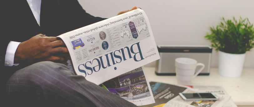 Homme lisant un journal avec un article sur les subventions non perçues