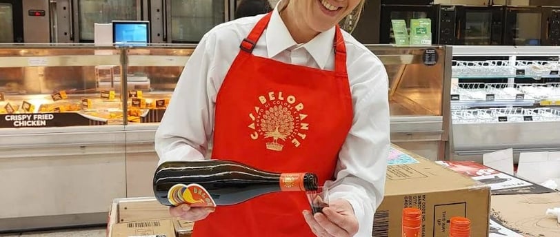 A woman in a red apron and a red apron. Morrisons Launches In-Store Sampling to Enhance Customer Exp