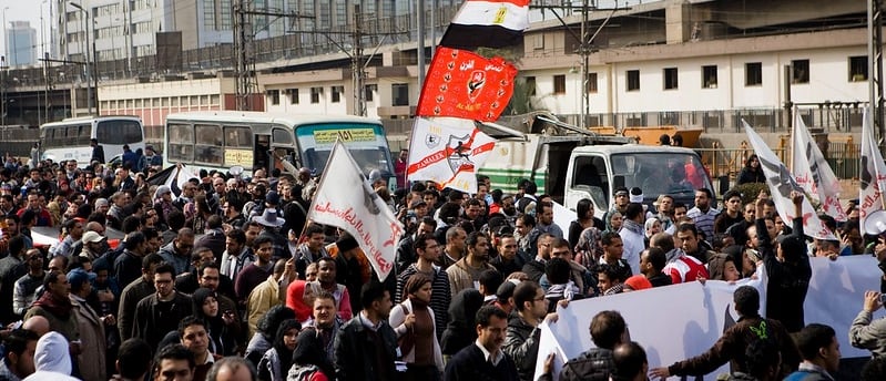 a large group of people standing in a city street, Egypt