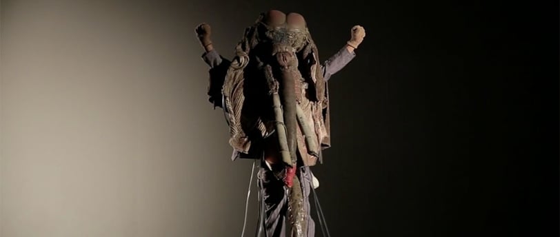 David Noir levant les bras dans son costume de pachyderme de "Défense du masque Ulin"