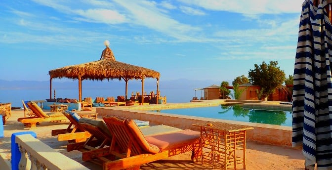 a beach resort with lounge chairs and umbrellas
