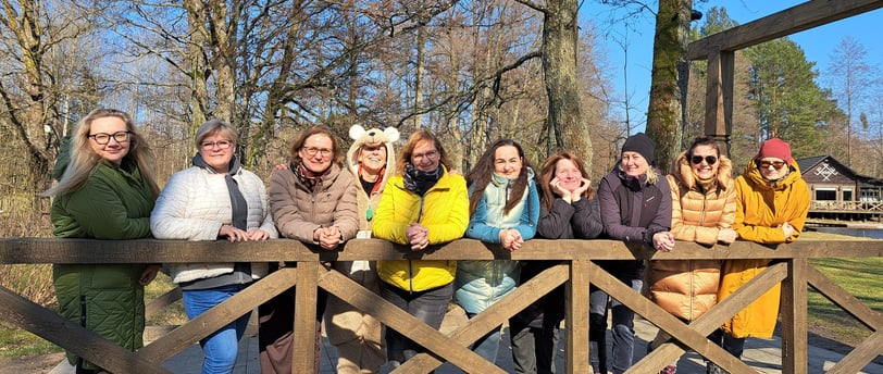 a group of happy women standing on a bridge