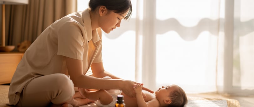 Mẹ Việt massage nhẹ nhàng cho trẻ sơ sinh trong ánh nắng sớm, thể hiện lợi ích massage cho bé