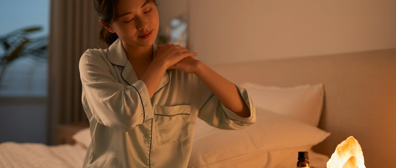 Người phụ nữ massage vai thư giãn trước khi ngủ trong không gian ấm cúng