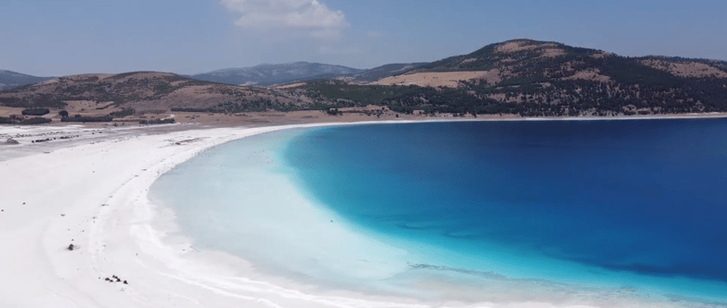 The Lake Salda shores with a blue sky and a hill in the background