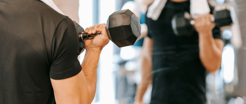 A imagem, feita em ambiente de academia, representa práticas de força que podem integrar rotinas de HIIT — treino de alta int