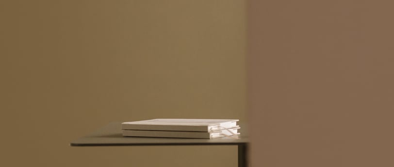 livres empilés sur un plateau minimaliste, reflétant l'élégance et la simplicité.