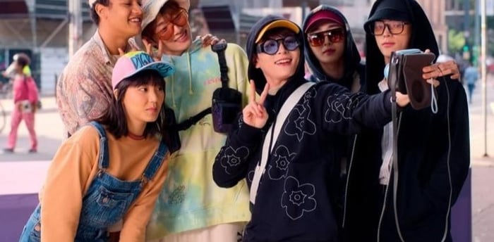 Uma grupo de koreanos posando para uma selfie.